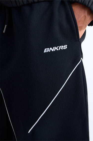 Bonkerscorner UAE Pitlane Straight Track Pants in black, featuring sporty design and comfortable fit, shown on a model.