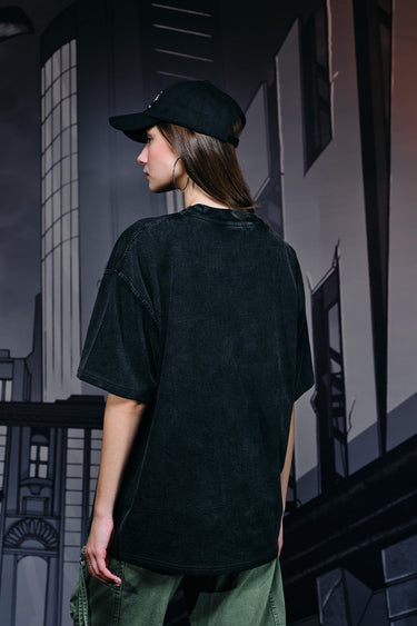 Faded oversized T-shirt featuring a bat emblem graphic by Bonkers Corner, casual streetwear style, light distressed look.