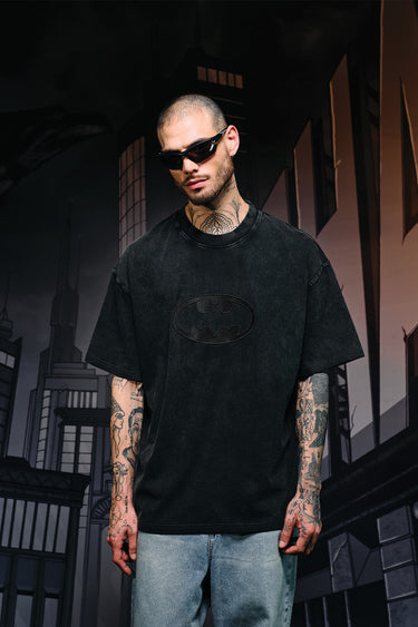 Faded black oversized T-shirt with a bat emblem graphic on the front, from Bonkers Corner, casual streetwear style.