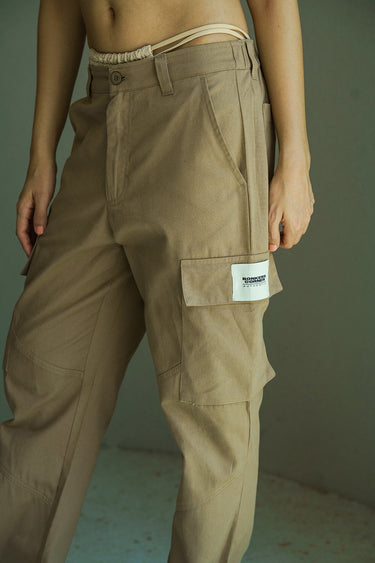 Beige cargo pants with utility pockets from Bonkers Corner, featuring a relaxed fit and functional design.