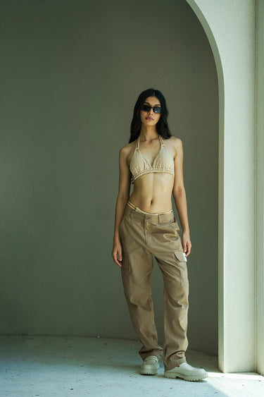 Beige cargo pants with utility pockets from Bonkers Corner, shown in a close-up view highlighting the fabric and pocket details.