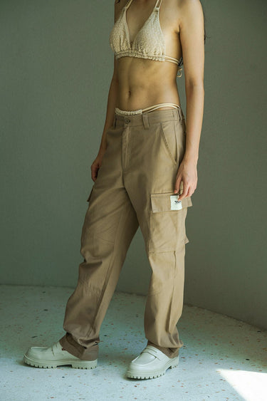 Beige cargo pants with utility pockets from Bonkers Corner, featuring a relaxed fit and multiple functional pockets.