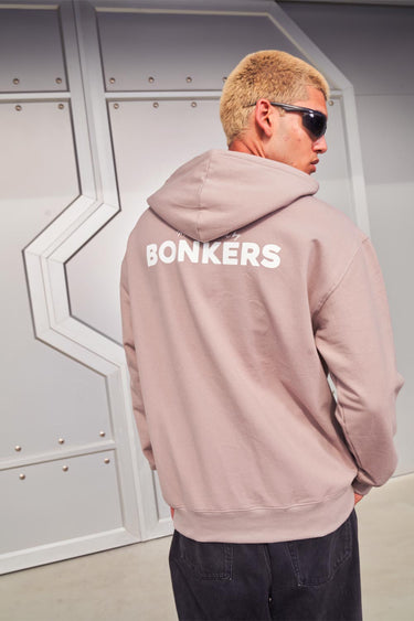 Beige limited edition Bonkers Corner hoodie with soft fabric and front pocket, displayed on a hanger.