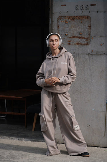 Beige limited edition hoodie from Bonkers Corner with a relaxed fit and soft fabric, shown on a hanger.