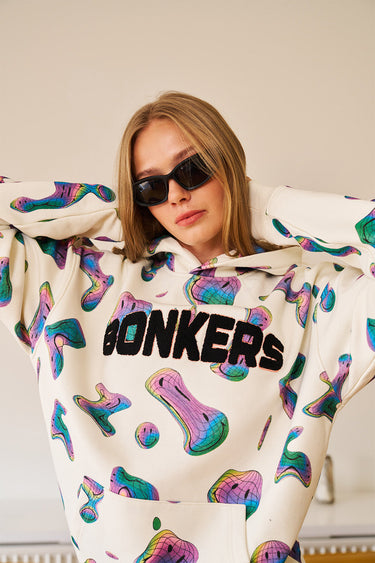 Beige Smiley Originals hoodie by Bonkers Corner featuring a casual fit and a cheerful smiley face graphic on the front.