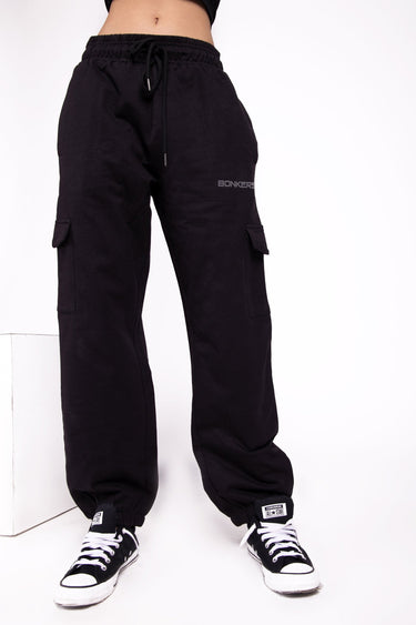 Black cargo pants by Bonkers Corner featuring multiple pockets and a relaxed fit, shown in a casual outdoor setting.