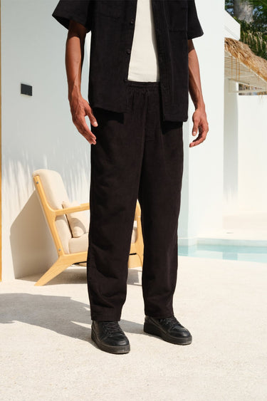 Bonkers Corner black corduroy pants, slim fit style with textured fabric, shown on a model in a casual setting