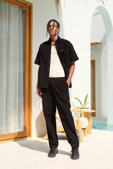 Black corduroy pants from Bonkers Corner featuring a slim fit and classic corduroy texture, shown on a model.