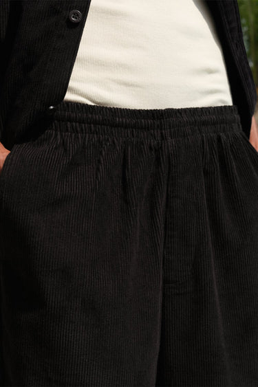 Black corduroy pants from Bonkers Corner, featuring a slim fit design and textured fabric, shown on a neutral background.