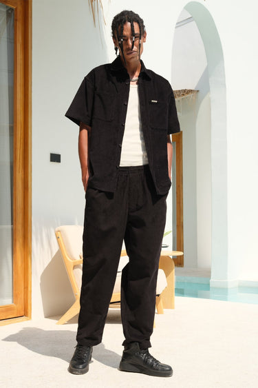 Black corduroy pants by Bonkers Corner, shown in a close-up image highlighting the textured fabric and classic fit.