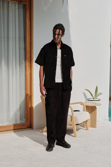 Black corduroy pants by Bonkers Corner, shown in a close-up view highlighting the textured fabric and classic fit.