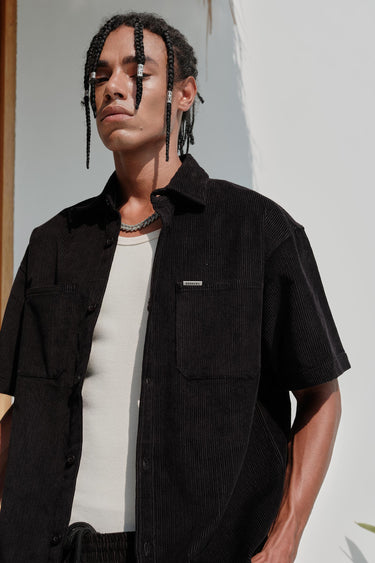 Black corduroy shirt by Bonkers Corner, featuring a classic button-up design and textured fabric.