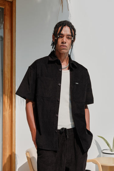 Black corduroy shirt by Bonkers Corner, featuring a classic button-up design and textured fabric, shown on a model.