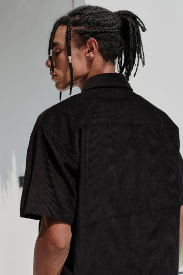 Black corduroy shirt by Bonkers Corner, featuring a classic button-up design and textured fabric, shown on a model.