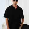Black knit textured polo T-shirt by Bonkers Corner, showcasing a close-up of the fabric and classic polo collar.