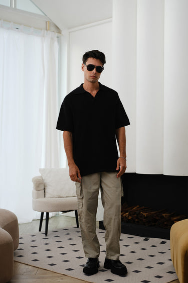 Black knit textured polo T-shirt by Bonkers Corner featuring a classic collar and subtle fabric pattern.