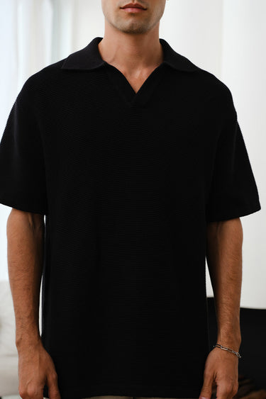 Black knit textured polo t-shirt by Bonkers Corner, close-up of fabric detail and collar on a mannequin.