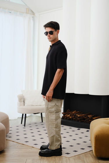 Black knit textured polo T-shirt by Bonkers Corner, close-up of fabric and collar detail.