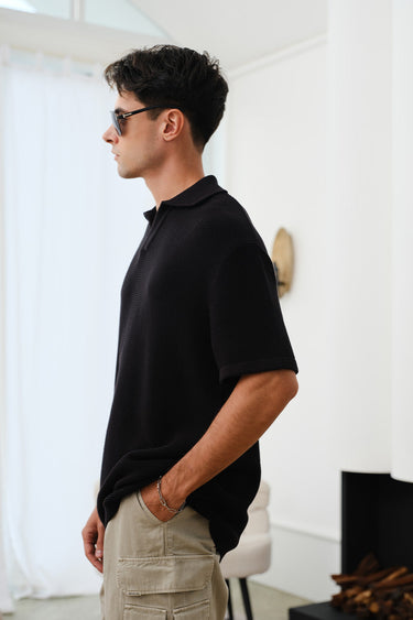 Black knit textured polo T-shirt by Bonkers Corner, close-up of fabric detail and classic polo collar.