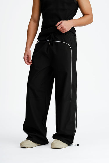 Black sporty deconstructed loose pants by Bonkers Corner, featuring a relaxed fit and casual athletic style.