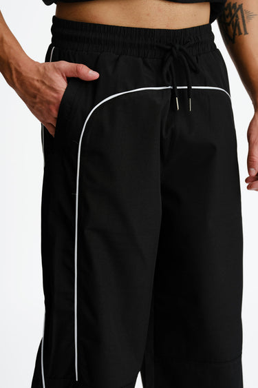 Black sporty deconstructed loose pants by Bonkers Corner, featuring relaxed fit and casual style, shown on a model.