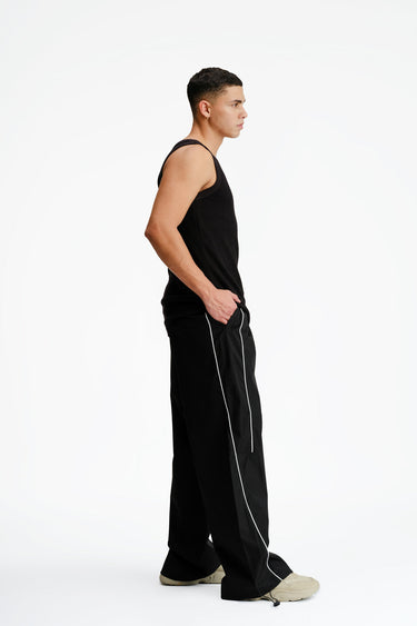 Black sporty deconstructed loose pants by Bonkers Corner, featuring relaxed fit and casual style.