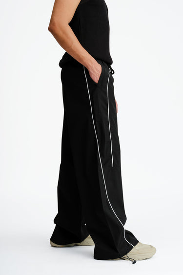 Black sporty deconstructed loose pants by Bonkers Corner with a relaxed fit and casual style, shown on a plain background.