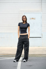 Black sporty deconstructed loose pants by Bonkers Corner, made from lightweight fabric with a relaxed fit and casual style.