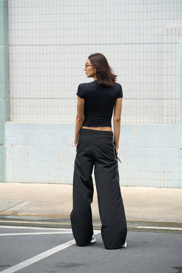 Black sporty deconstructed loose pants by Bonkers Corner, featuring a relaxed fit and casual athletic style.