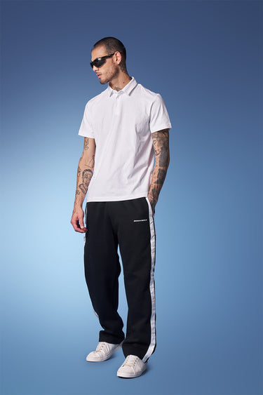 Black sporty straight-fit pants by Bonkers Corner, shown on a model, featuring a comfortable elastic waistband and tapered leg fit.