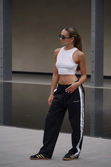 Black sporty straight fit pants by Bonkers Corner, shown flat with elastic waistband and side pockets.