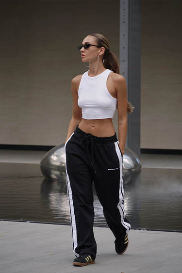 Black sporty straight fit pants by Bonkers Corner, shown laid flat with elastic waistband and slim-leg design.