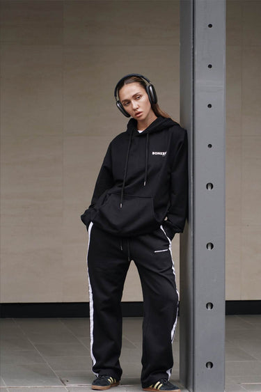 Black sporty straight fit pants by Bonkers Corner, shown flat with elastic waistband and side pockets.