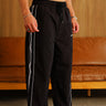 Black wide leg joggers with tape details from Bonkers Corner, featuring a relaxed fit and comfortable fabric.