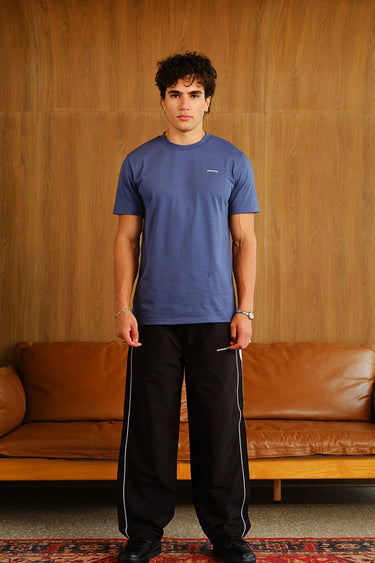 Black wide-leg joggers with tape detailing from Bonkers Corner, featuring a relaxed fit and casual style.