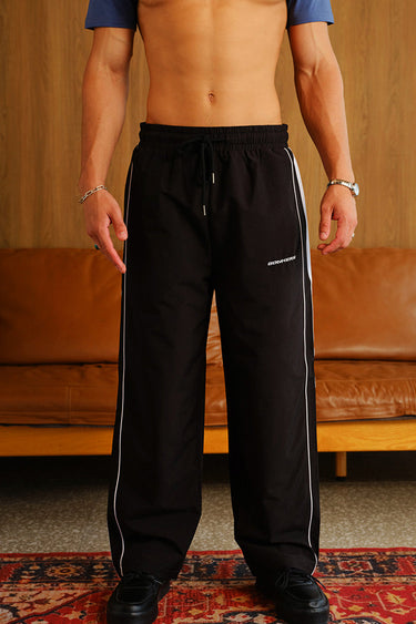 Black wide-leg joggers with tape detailing from Bonkers Corner, featuring a relaxed fit and comfortable fabric.