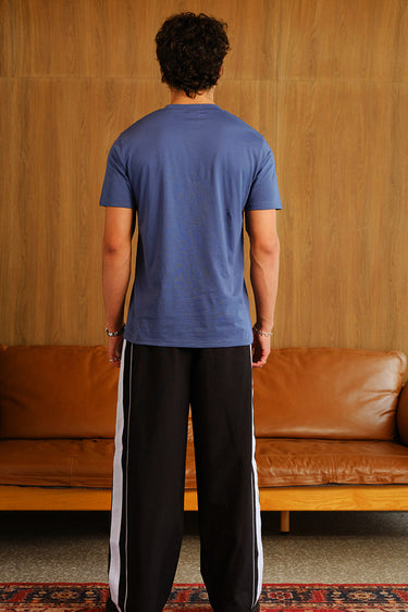 Black wide-leg joggers with tape detail from Bonkers Corner, featuring a relaxed fit and elastic waistband.