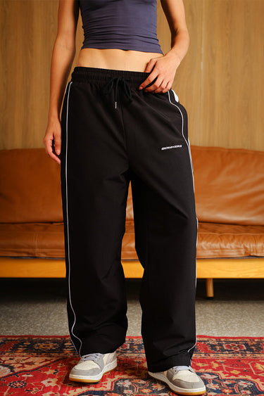 Black Tape Wide Leg Joggers by Bonkers Corner featuring a relaxed fit and comfortable design with tape accents.