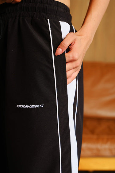 Black wide-leg joggers with tape detail from Bonkers Corner, featuring a relaxed fit and casual style.
