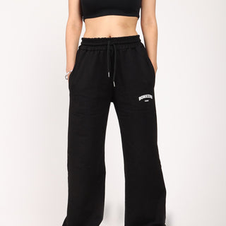 Black wide-leg sweatpants by Bonkers Corner, featuring a relaxed fit and soft fabric, shown on a model.
