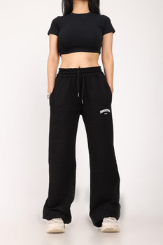 Black wide-leg sweatpants by Bonkers Corner, featuring a relaxed fit and soft fabric, shown on a model.