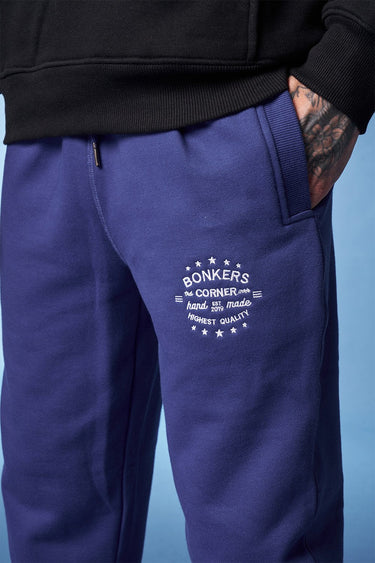 Blue heavyweight joggers by Bonkers Corner featuring a relaxed fit and elastic waistband, shown on a model in a casual setting.