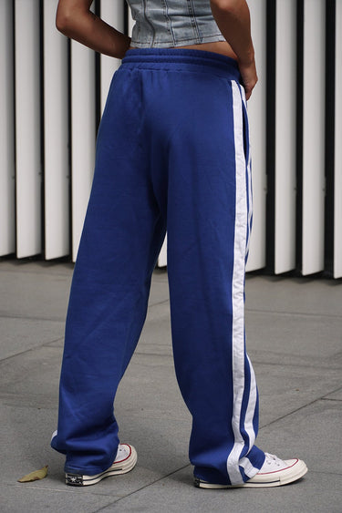 Blue sporty straight fit pants by Bonkers Corner, shown laid flat with elastic waistband and sleek design.