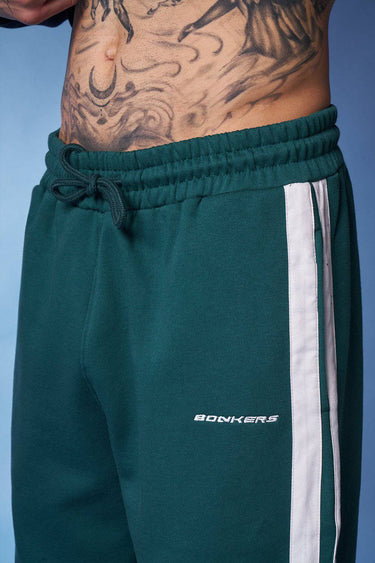 Bottle green sporty straight fit pants by Bonkers Corner, shown on a model, with a focus on the casual athletic style and fit.