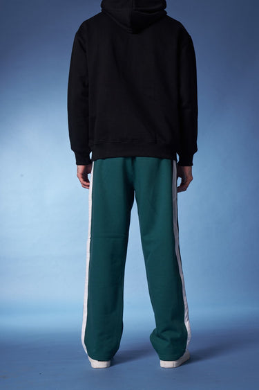 Bonkers Corner bottle green sporty straight fit pants displayed in a natural pose, highlighting the casual athletic style and fabric.
