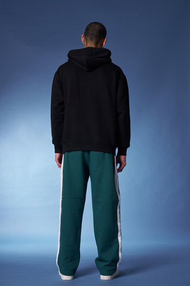 Bonkers Corner bottle green sporty straight fit pants displayed with a focus on the relaxed, athletic style and fabric details.