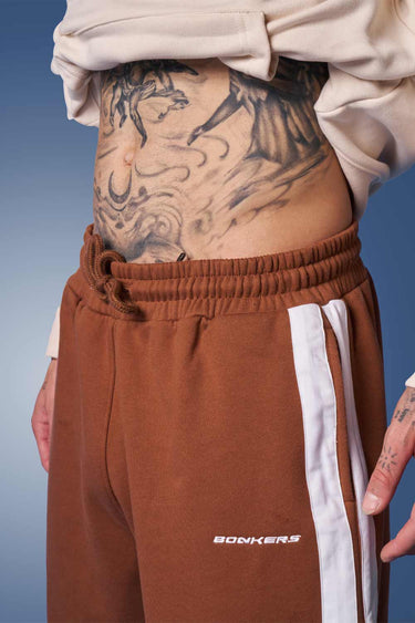 Brown sporty straight fit pants by Bonkers Corner, shown on model with casual fit and elastic waistband.