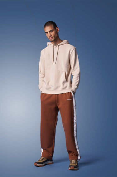 Brown sporty straight fit pants by Bonkers Corner shown on model, featuring a casual, athletic style with a relaxed straight-leg cut.