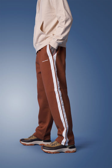 Brown sporty straight-fit pants by Bonkers Corner, featuring a comfortable design and casual style, shown on a model.