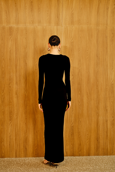 Bonkers Corner Eclipse Black Maxi Dress hanging on a hanger, showcasing its flowy fabric and elegant design.